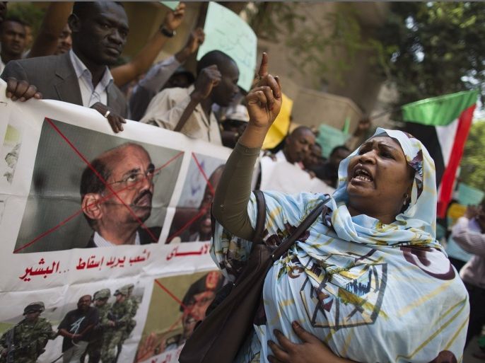 A Sudanese woman chants slogans against longtime President Omar al-Bashir during a protest in front of the Sudanese embassy in Cairo, Egypt, Sunday, Sept. 29, 2013. Sudanese security forces in pickup trucks opened fire Saturday, Sept. 28 on hundreds of mourners marching after the funeral of a protester killed a day earlier, the latest violence in a week of demonstrations calling for the ouster of al-Bashir. Arabic on the banner reads, "the people want to bring down al-Bashir."