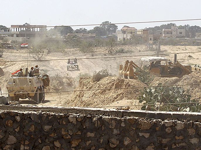 A picture taken from the Southern Gaza Strip shows Egyptian soldiers using bulldozers in search of tunnels on the border with Egypt and the Gaza Strip on September 8, 2013. The Egyptian military has been facing an insurgency in north Sinai, a haven for Al-Qaeda-inspired militants who have launched almost daily attacks against security forces in recent weeks. AFP PHOTO/SAID KHATIB