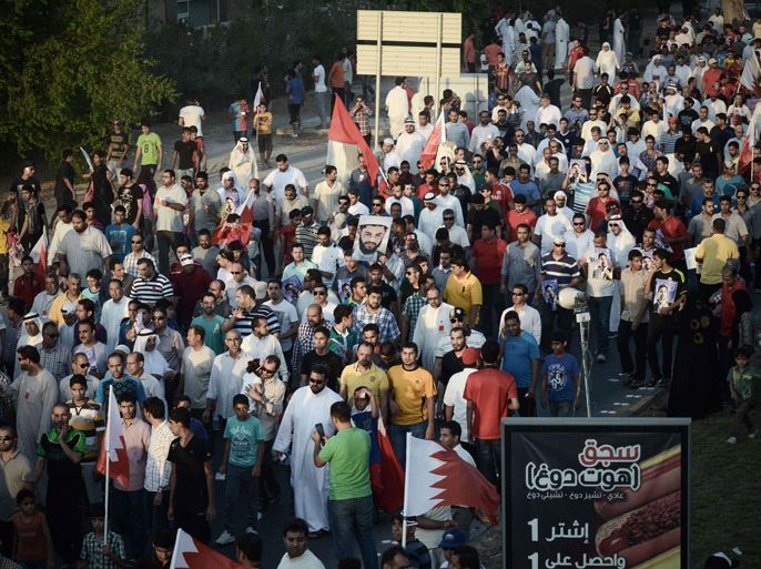 Bahraini protesters wave their national flags as they take part in an anti-government protest in the village of Jannusan, west of the capital Manama, on September 27, 2013. Thousands took to the streets in Bahrain to condemn the arrest of ex-MP Marzooq, hours after clashes between protesters and police, officials and witnesses said. AFP PHOTO