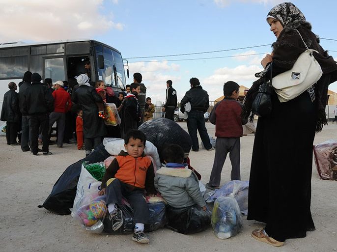 عائلة سورية قبيل ركوبها الحافلة التي تقلها للحدود الأردنية - خبر عن عودة اللاجئين السوريين