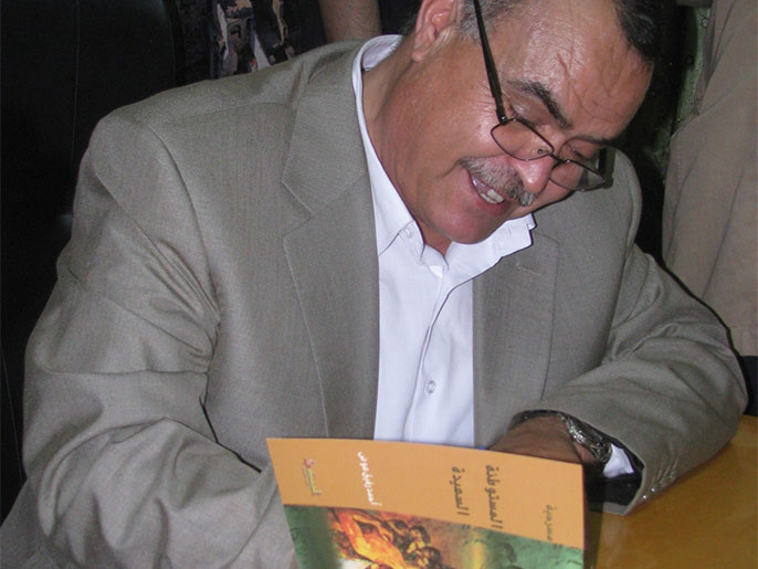 الكاتب أحمد رفيق عوض خلال توقيع المسرحية (الجزيرة)
