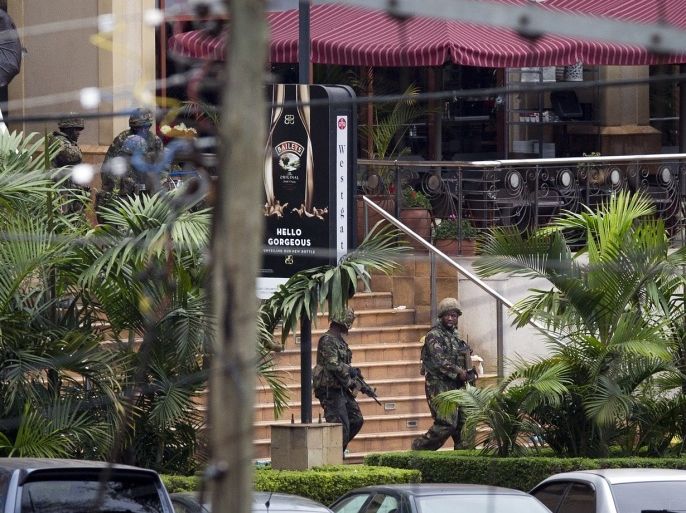 Soldiers from the Kenya Defense Forces walk out, following the sound of explosions and gunfire, from the Westgate Mall in Nairobi, Kenya Sunday, Sept. 22, 2013. Associated Press journalists at the scene of a hostage standoff said a barrage of gunfire erupted from the upscale Kenyan mall Sunday morning and moments later two wounded Kenyan security forces were carried out of the mall.