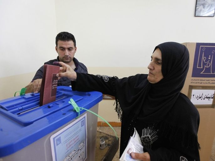 An Iraqi Kurd woman casts her vote into a ballot box during regional parliamentary elections at a polling station in Arbil, capital of the autonomous Kurdistan region, about 350 km (217 miles) north of Baghdad, September 21, 2013. Kurds went to the polls on Saturday to elect a new parliament in an election that is being dubbed as the most crucial in the history of Iraqi Kurdish political powers, with potential to change the political structure of the next parliament and government cabinet. About 1,129 candidates representing 32 political entities are competing for 100 parliamentary seats. Other nominees representing Christian, Turkmen and Armenian minorities in the region are competing for 11 additional seats.