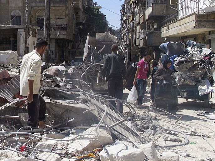 Civilians carry bags as they make their way through rubble of buildings damaged by what activists said was shelling by forces loyal to Syria's President Bashar al-Assad in Aleppo's Bustan al-Qasr district, September 9, 2013. Picture taken September 9, 2013. REUTERS/Abdalghne Karoof (SYRIA - Tags: POLITICS CIVIL UNREST CONFLICT)