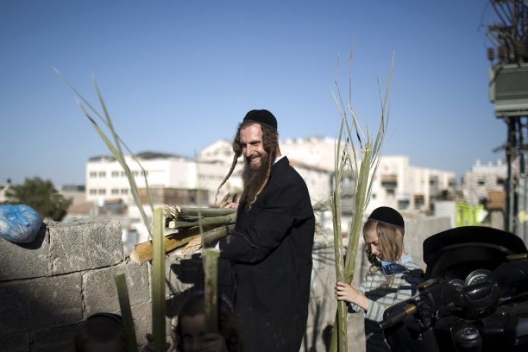 An ultra-Orthodox Jewish man and his children carry palm branches for the roof of the tabernacles used during the celebration of Sukkot, the feast of the Tabernacles, in an Ultra Orthodox neighbourhood of Jerusalem on September 17, 2013. The Sukkot feast begins on September 19 and commemorates the exodus of Jews from Egypt some 3200 years ago.