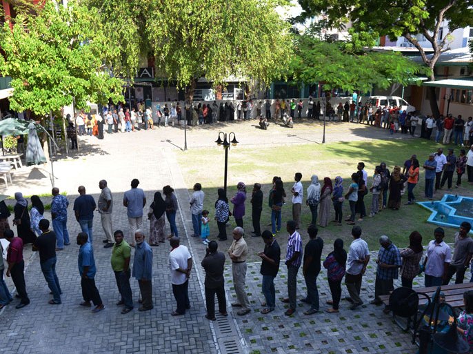 -, MALDIVES : Maldivian voters line up at a local polling station in Male on September 7, 2013. Some 139,000 registered voters will choose a new President. Voters across the Maldives came out in force to vote in an election that could see the honeymoon islands' first freely elected leader return to power, 18 months after he was toppled. AFP PHOTO/Roberto SCHMIDT