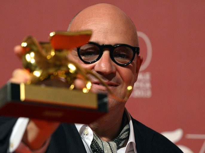 VEN2707 - Venice, -, ITALY : Italian director Gianfranco Rosi poses with the Golden Lion for Best Film for his movie "Sacro Gra" during the award ceremony of the 70th Venice Film Festival on September 7, 2013 at Venice Lido. AFP PHOTO / GABRIEL BOUYS