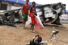 Sudanese boys walk amid burned vehicles after rioters torched a fuel station in Khartoum, Sudan, Thursday, Sept. 26, 2013. Sudanese authorities have deployed troops around vital installations and gas stations in Khartoum following days of deadly rioting over gas price hikes.