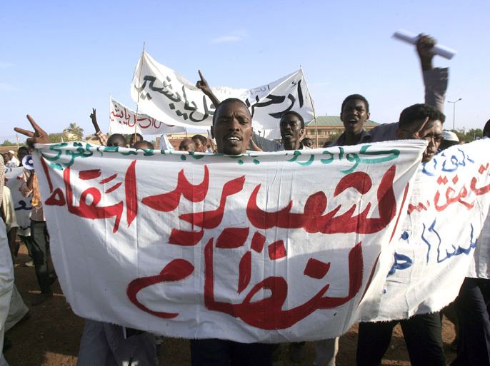 Omdurman, -, SUDAN : Holding a banner that reads in Arabic, "The people want the fall of the regime", supporters of former prime minister (1986-1989) and now head of the National Umma Party (NUP), religious leader Sadiq al-Mahdi, rally in Khalifa Square in Sudan’s twin capital of Omdurman on June 29, 2013. The NUP, the largest opposition party has called on its supporters across the country to attend the rally, marking 24 years (June 30) since the 1989 military coup led by now President Omar al-Bashir, against the multi-party government which was led by al-Mahdi. AFP PHOTO / ASHRAF SHAZLY