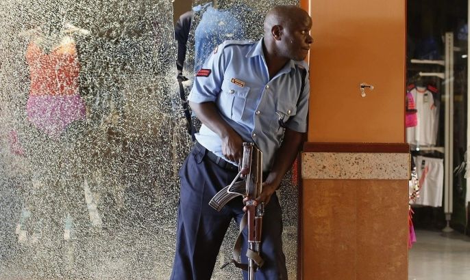 A police officer tries to secure an area inside the Westgate Shopping Centre where gunmen went on a shooting spree in Nairobi September 21, 2013. The gunmen stormed the shopping mall in Nairobi on Saturday killing at least 20 people in what Kenya's government said could be a terrorist attack, and sending scores fleeing into shops, a cinema and onto the streets in search of safety. Sporadic gun shots could be heard hours after the assault started as soldiers surrounded the mall and police and soldiers combed the building, hunting down the attackers shop by shop. Some local television stations reported hostages had been taken, but there was no official confirmation.