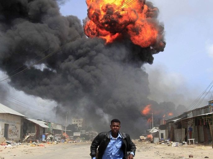A Somali policeman runs from the scene of an accidental explosion at a petrol storage facility within the former United States residential housing in capital Mogadishu, September 3, 2013.