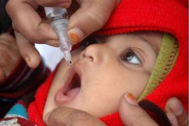 A volunteer administers pulse polio drops to a child at a booth in Bhopal, India, 20 January 2013. Children between the ages of zero and five years old are to be given pulse polio drops in a state campaign to get rid of the disease.