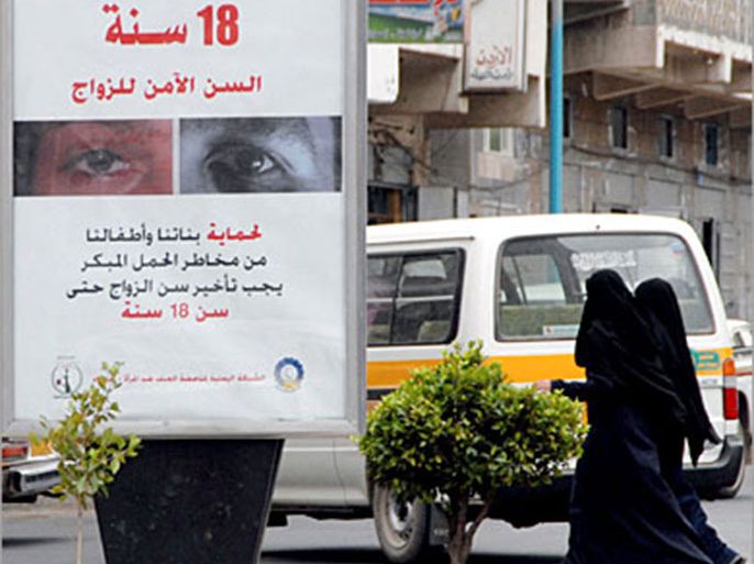 afp / yemeni women walk past a an advertisement reading in arabic '18 is the safe age for marriage, in order to protect our daughters and children from the dangers of early pregnancy, (الفرنسية)