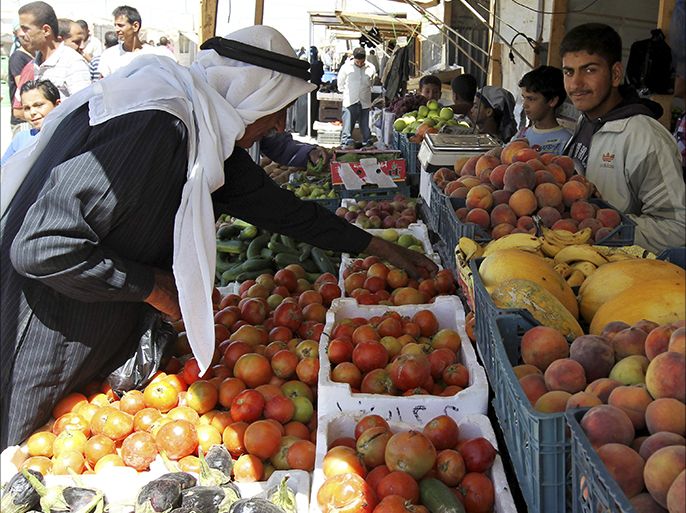 A Syrian refugee man buys fruits and vegetables from a shop at the main market at Al Zaatri refugee camp in the Jordanian city of Mafraq, near the border with Syria September 8, 2013. REUTERS/Muhammad Hamed (JORDAN - Tags: SOCIETY)