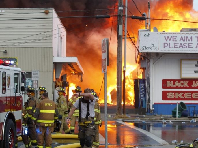 A handout provided by the The Star Ledger shows firefighters pulling back as they battle a six-alarm fire fueled by strong winds consumes the south end of the Seaside Park, New Jersey Boardwalk in Seaside Park, New Jersey, USA, 12 September 2013.