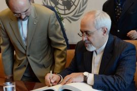 Javad Zarif, Iran's Foreign Minister (R) signs a guest book before his meeting with United Nations Secretary General Ban Ki-Moon (not pictured) September 19, 2013 at UN headquarters in New York.
