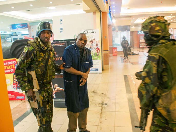 A severly wounded man is rescued by Kenyan troops at the Westgate Mall on September 21, 2013 in Nairobi. Kenyan troops were locked in a fierce firefight with Somali militants inside an upmarket Nairobi shopping mall on September 22 in a final push to end a siege that has left at least 59 dead and some 200 wounded with an unknown number of hostages still being held. Somalia's Al Qaeda-inspired Shebab rebels said the carnage at the part Israeli-owned complex mall was in retaliation for Kenya's military intervention in Somalia, where African Union troops are battling the Islamists. AFP PHOTO JAMES QUEST