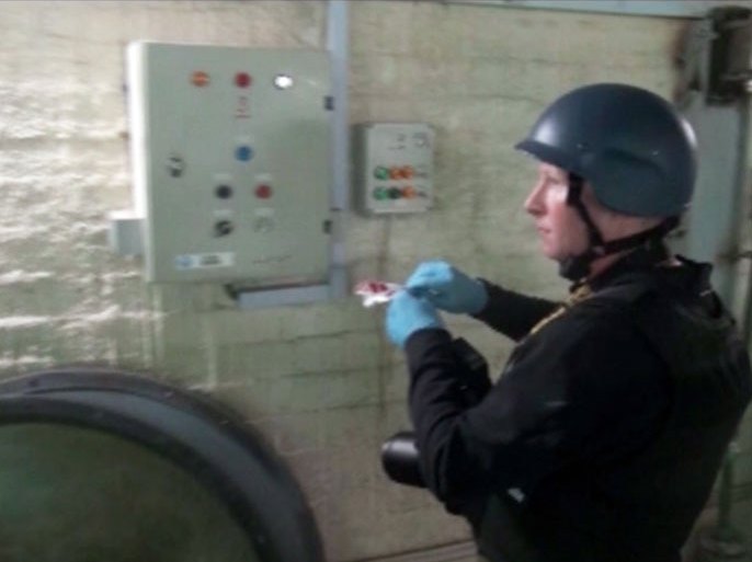 A TV grab from the Syrian television made on 08 October 2013 showing an inspector of the Organization for the Prohibition of Chemical Weapons (OPCW) working at an undisclosed place in Syria. Reports on 11 October 2013