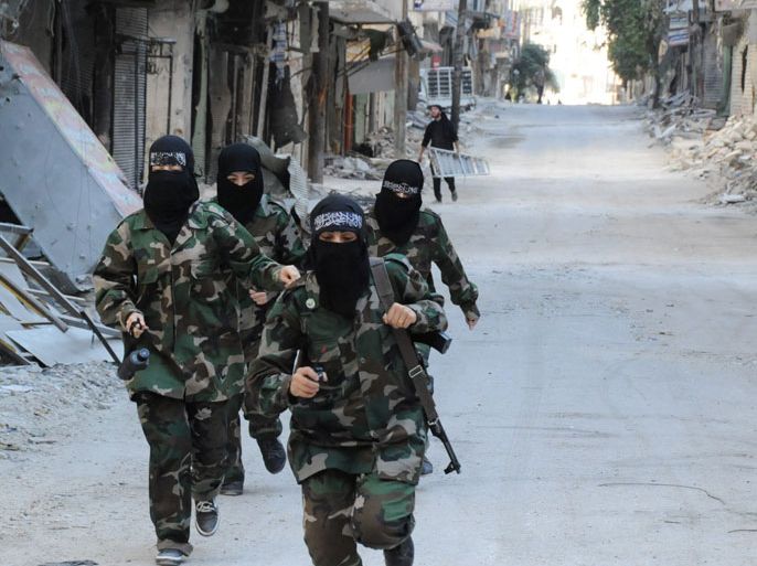 أم عمر ومقاتلات في كتيبة أمنا عائشة يركضن عبورا لأحد الشوارع التي يتمركز فيها قناص للجيش النظامي في حي صلاح الدين بحلب