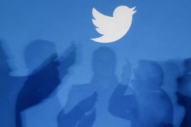 The shadows of people holding mobile phones are cast onto a backdrop projected with the Twitter logo in this illustration picture taken in Warsaw September 27, 2013. REUTERS/Kacper Pempel