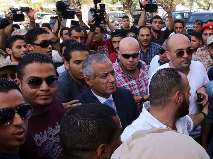 Libyan Prime Minister Ali Zeidan (C) arrives at the government headquarters in Tripoli on October 10, 2013 shortly after he was freed from the captivity of militiamen who had held him for several hours. Gunmen seized Zeidan from a hotel, where he resides, in the Libyan capital and held him for several hours before he was freed, in the latest sign of Libya's lawlessness since Moamer Kadhafi was toppled in 2011. AFP PHOTO / MAHMUD TURKIA