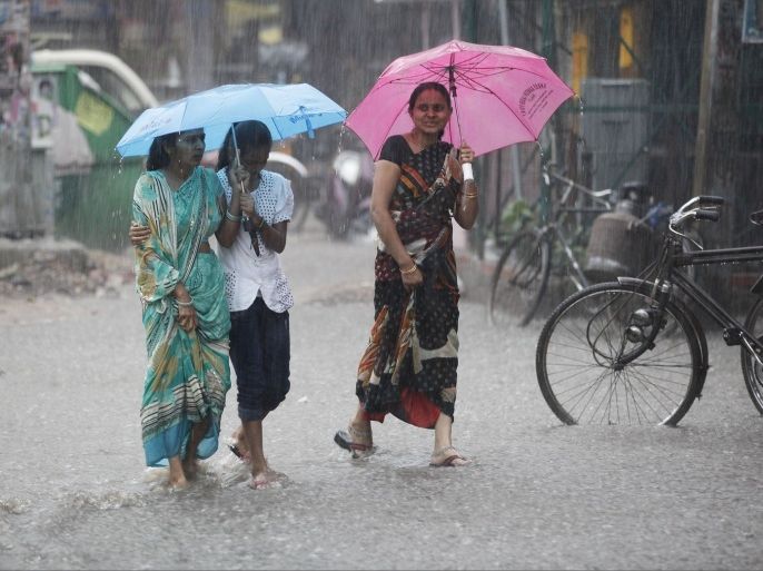Indians walk under umbrellas during heavy downpour in Allahabad, India, Sunday, Sept. 29, 2013. India's monsoon season, which runs from June to September, brings rain that is vital to agriculture.