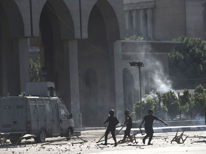 Egyptian riot police remove debris during clashes with student of the al-Azhar University outside their university camps in Cairo, on October 20, 2013, during an anti-army protest. About 3,000 students initially blocked the main Nasr road leading to the Islamic university's campus, and clashed with police who arrived to persuade them to leave, the interior ministry said in a statement. AFP P