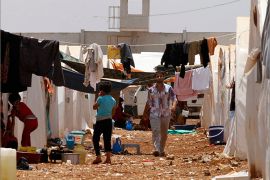 Syrian refugees walk under clothing lines at the Bab Al-Salam refugee camp in Azaz, near the Syrian-Turkish border June 9, 2013. REUTERS/Hamid Khatib (SYRIA - Tags: SOCIETY POLITICS CIVIL UNREST)