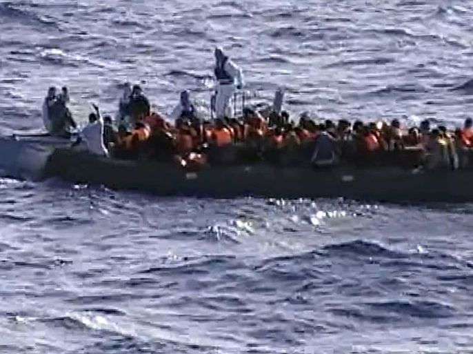 This picture grabbed on a video released by the Italian Navy on October 13, 2013 shows immigrants aboard a raft while being rescued from the sea by crew members of a naval vessel, off the Italian island of Lampedusa. Humanitarian agencies say nearly 20,000 migrants have perished while trying to cross the Mediterranean Sea into Europe over the past 20 years. Some 30,000 migrants have landed in Italy this year -- four times more than in 2012