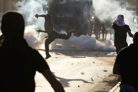 An anti-government protester throws stones at riot police during clashes after the funeral procession of 17-year-old Ali Khalil in the village of Bani Jamra west of Manama, October 23, 2013.