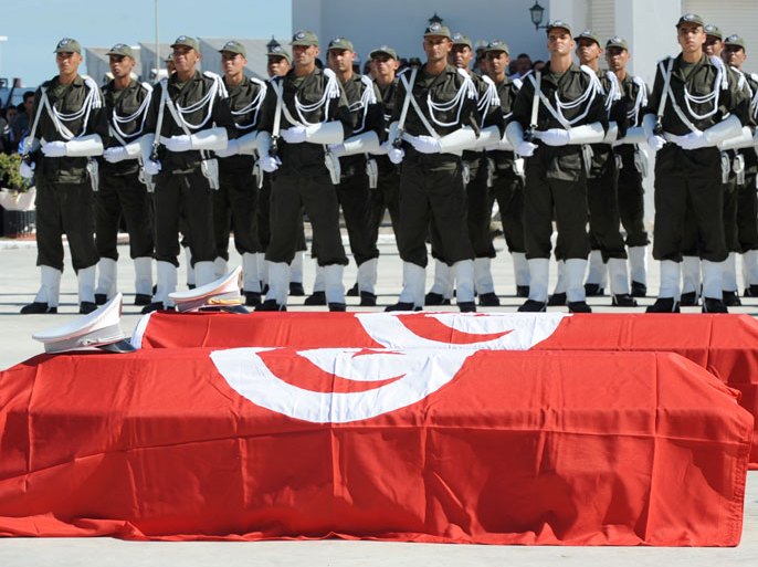 The coffins of the two gendarmes that were killed by an armed group in the Neja region are displayed in front of members of security forces during a memorial ceremony on October 18, 2013 at the military barracks in the Tunis suburb of L'Aouina. Angry members of the security forces drove notably Tunisia's President and Prime Minister away from the ceremony. Since December, security forces have been tracking a group of militants allegedly linked to Al-Qaeda in the Chaambi mountain region along the Algerian border, with some 15 soldiers and police killed in the operations. AFP PHOTO FETHI BELAID
