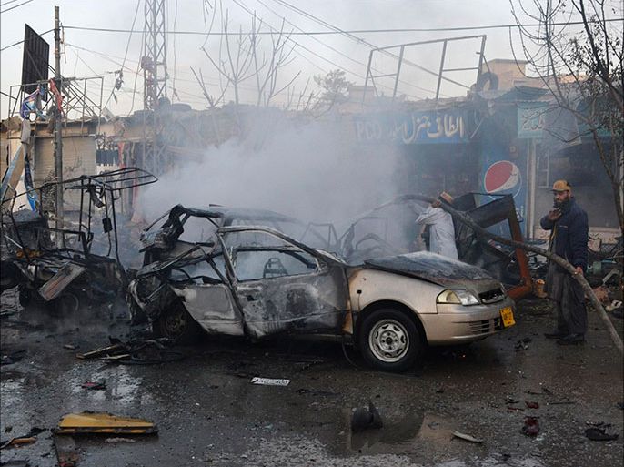 Firefighters spray water to extinguish burning vehicles at the site of a bomb attack along Double Road, also known as Zarghoon Road, in Quetta October 30. 2013