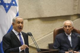 GAL005 - JERUSALEM, -, - : Israeli Prime Minister Benjamin Netanyahu gestures as he delivers a speech near President Shimon Peres (R) during the opening of the Knesset's (Israel's parliament) winter session, on October 14, 2013 in Jerusalem. Easing pressure on Iran over its nuclear programme would be an "historic mistake," Netanyahu warned during his speech, a day before world powers resume talks with Tehran. AFP PHOTO/GALI TIBBON