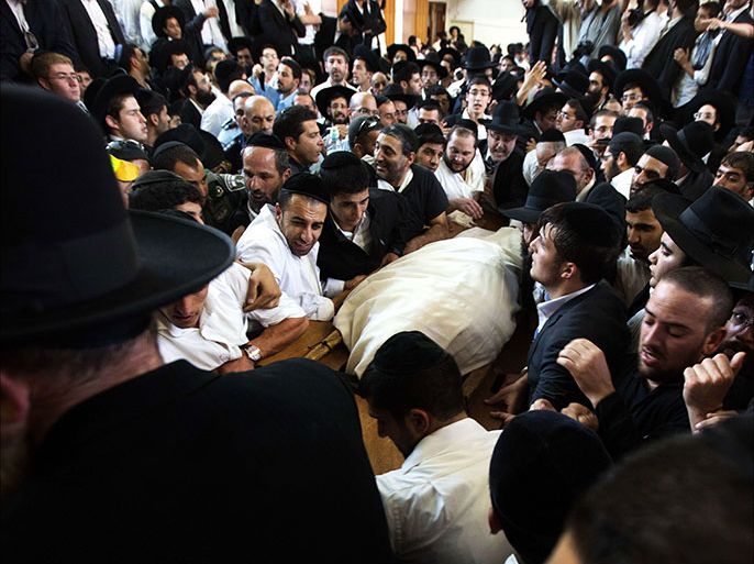 Ultra-orthodox Jewish mourners grieve around the body of their Rabbi Ovadia Yosef during his funeral in Jerusalem on October 7 2013. Rabbi Ovadia Yosef, the greatest spiritual leader of the ultra-Orthodox Sephardic Judaism community and the mentor of their Shas party died today on age 93 years, in Hadassah Ein Kerem Hospital in Jerusalem, where he was admitted for the last two weeks more than half a million of his followers attend the funeral. AFP PHOTO/MENAHEM KAHANA