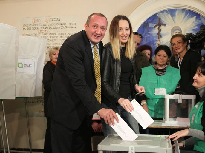 epa03926330 Georgian presidential candidate of 'Georgian Dream party' Giorgi Margvelashvili (L) and his daughter Ana (R) cast ballots at a polling station during the presidential elections, Tbilisi, Georgia, 27 October 2013. Georgia holds a presidential election on Sunday largely seen as a confidence vote on Prime Minister Bidzina Ivanishvili's drive for closer ties with Russia. Some 3.5 million registered voters could decide the first peaceful handover of the largely ceremonial office of head of state in the Caucasus country's turbulent post-Soviet era. Incumbent President Mikheil Saakashvili, who has been in office since 2004, is barred by the constitution from serving another term. EPA/ZURAB KURTSIKIDZE