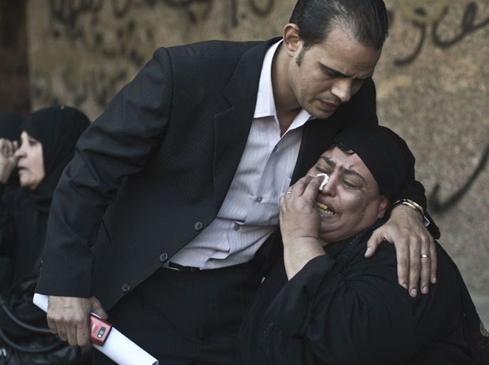 An Egyptian relative of one of the victims of a shooting spree targeting a wedding at a Cairo Coptic Church is comforted as she mourns at a morgue in the capital on October 21, 2013. Late on October 20, a gunman riding on the back of a motorbike sprayed bullets at a group as it emerged from a wedding service at the Church of the Virgin in the working class neighbourhood of Al-Warrak. AFP PHOTO / KHALED DESOUKI