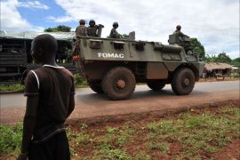 Soldiers from the Central African Multinational Force (FOMAC) patrol on an armoured vehicle in a village near Bangui on October 6, 2013 during an operation to secure the disarmament of former Seleka rebels. The poor, landlocked nation plunged into chaos earlier this year when a coalition of rebels and armed movements ousted president Francois Bozize in March. AFP PHOTO / ISSOUF SANOGO