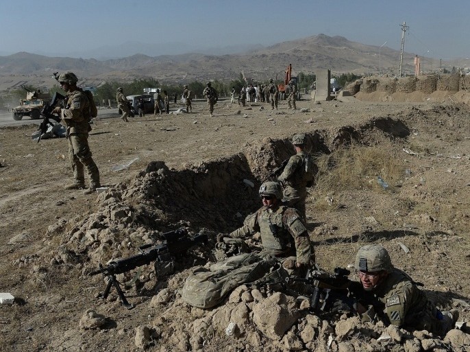 US soldiers keep watch at the site of a suicide attack in Maidan Shar, the capital city of Wardak province south of Kabul on September 8, 2013. At least four Afghan intelligence agents were killed and dozens of civilians were wounded when a group of Taliban militants attacked an intelligence bureau in central Afghanistan, officials said.