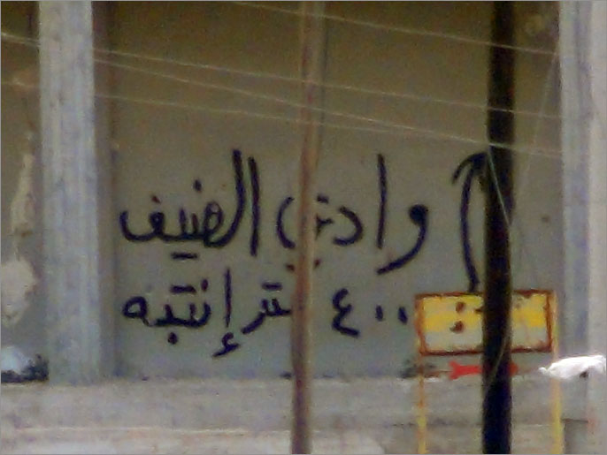 كتابة على الحائط للتحذير من معسكر وادي الضيف (الجزيرة)
