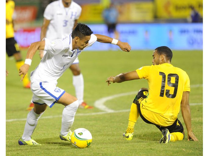 Honduran player Andy Ariel Rodriguez Najar (L) evades the challenge of Jamaica's Adrian Mariappa in their CONCACAF World Cup qualifier Jamaica vs Honduras in Kingston, Jamaica on October 15, 2013.