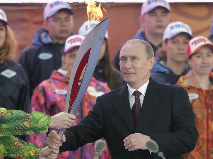 Russian President Vladimir Putin takes a torch in Moscow on October 5, 2013, to start the relay across Russia, as the Olympic Flame for the XXII Winter Olympic Games Sochi 2014 arrived in Russia . AFP PHOTO / ALEXANDER NEMENOV