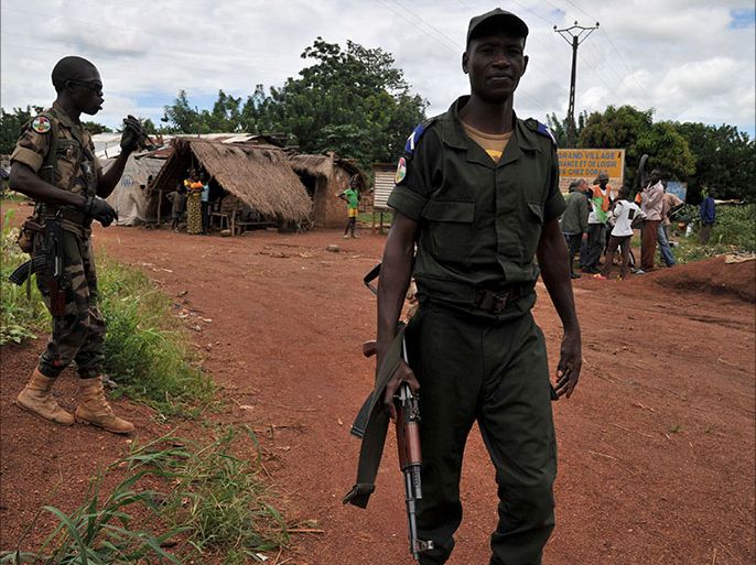 Soldiers from the Central African Multinational Force (FOMAC) walk in a village near Bangui on October 6, 2013 during an operation to secure the disarmament of former Seleka rebels. The poor, landlocked nation plunged into chaos earlier this year when a coalition of rebels and armed movements ousted president Francois Bozize in March. AFP PHOTO / ISSOUF SANOGO