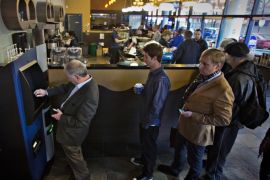 Customers line-up to use the world's first ever permanent bitcoin ATM unveiled at a coffee shop in Vancouver, British Columbia October 29, 2013. The kiosk, built by Las Vegas RoboCoin and operated by local dealer Bitcoiniacs, will allow users to withdraw their bit coins in the form of Canadian dollars or deposit cash to buy more bitcoins. REUTERS/Andy Clark (CANADA - Tags: BUSINESS SOCIETY SCIENCE TECHNOLOGY)