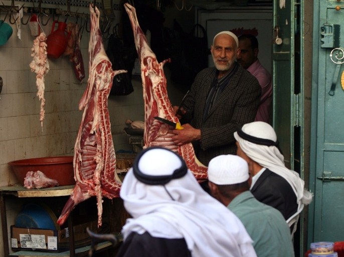 Palestinian men sit outside a butcher shop as they wait to buy meat in the old city of the West Bank city of Hebron on November 15, 2010, ahead of the Muslim holiday of Eid al-Adha or Feast of the Sacrifice, which marks the end of the annual hajj or pilgrimage to Mecca and is celebrated in remembrance of Abraham's readiness to sacrifice his son to God.