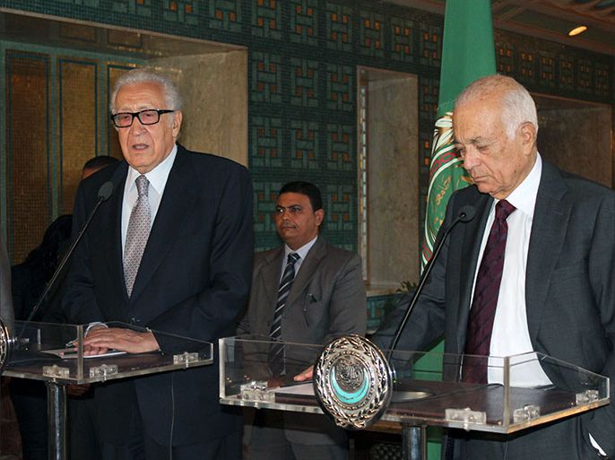 Arab League general secretary Nabil al-Arabi (R) listens to UN-Arab League envoy to Syria Lakhdar Brahimi speaking during a press conference following their meeting on October 20, 2013 in the Egyuptian capital, Cairo. A keenly anticipated peace conference for Syria will convene in Geneva on November 23, Nabil al-Arabi said. AFP PHOTO / STR