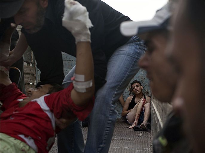(FILES) A picture taken on October 21, 2012 shows a wounded Syrian youth sitting on the back of a truck carrying victims and wounded people to hospital following an attack by regime forces in the northern city of Aleppo. AFP won several prizes on October 12, 2013 at the 20th Bayeux-Calvados awards for war correspondents, which this year was dominated by reporting of the Syrian conflict. Fabio Bucciarelli, a regular AFP contributor, received the Nikon Photo Award for "Battle to Death", a series of striking images taken during fighting in the city of Aleppo in 2012. The 32-year-old Italian photographer, an engineering graduate, has covered various conflicts including those in Sudan and Mali, as well as Syria. AFP PHOTO/FABIO BUCCIARELLI
