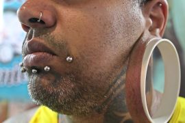 Brazilian tattoo artist "Bob" poses for pictures as he shows his modified ear lobe as he attends Tattoo Week in Sao Paulo, Brazil, Friday, July 19, 2013. Tattoo Week is an annual event that attracts international tattoo artists and body piercing artists as well as consumers.