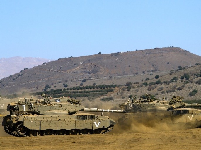 Israeli Merkava tanks roll in a training field in the Golan Heights, next to the Israeli-Syrian border, on October 10, 2013. The Israeli army fired on October 9, a Tammuz missile across the Syrian border in response to mortar fire from the Syrian at an Israeli military base in the northern Israeli-annexed Golan Heights leaving two soldiers with light wounds.