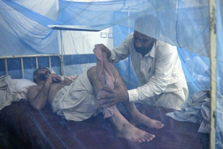This photograph taken on September 23, 2013 shows a relative assisting a dengue fever patient at a hospital in Mingora, the capital of Swat Valley. The dengue epidemic, which began in late August in Pakistan's Swat Valley (northwest), has killed at least 23 people with more than 6,500 cases reported, according to a report provided by the local authorities. Dengue fever is spread by mosquitoes that breed in stagnant water and causes flu-like symptoms accompanied by nausea and sometimes bleeding, but is rarely fatal.