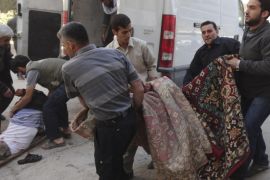Civilians transport casualties after what activists said was shelling by forces loyal to Syria's President Bashar al-Assad after Friday prayers in the Damascus suburb of Saqba October 11, 2013.